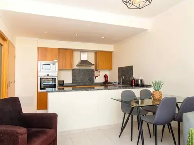 a kitchen with a counter and a table and chairs at View Waves Apartment by Stay ici Algarve Holiday Rental in Albufeira