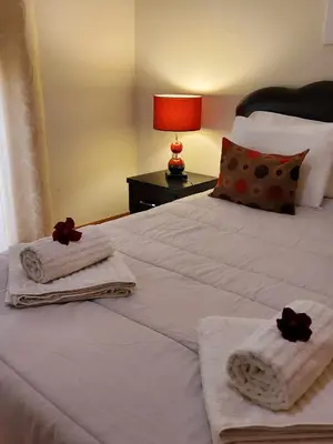 a bedroom with a bed with towels and a lamp at Sun & Nature Apartment Corcovada in Albufeira