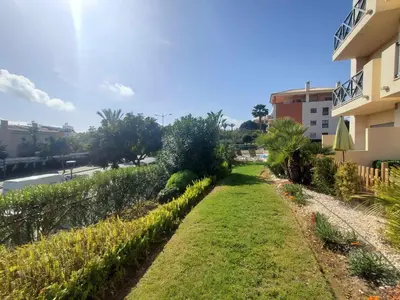 a garden in front of a building next to a street at Sun & Nature Apartment Corcovada in Albufeira
