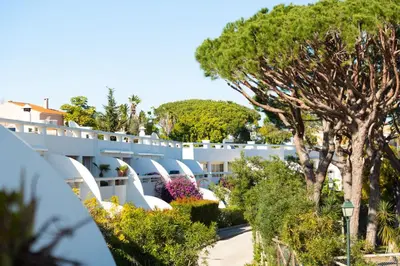 a view of the side of a building with trees at Cozy 2 BDR W/Balcony in Vale do Lobo by LovelyStay in Vale do Lobo