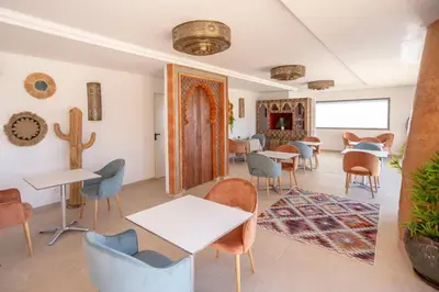 a room with tables and chairs and a cactus at Al Karob Yoga Boutique Hotel in Guia