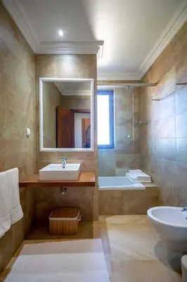 a bathroom with a sink and a mirror and a tub at Al Karob Yoga Boutique Hotel in Guia
