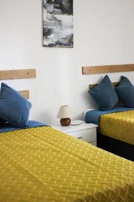 two beds in a room with blue and yellow at Casa Brito in Albufeira