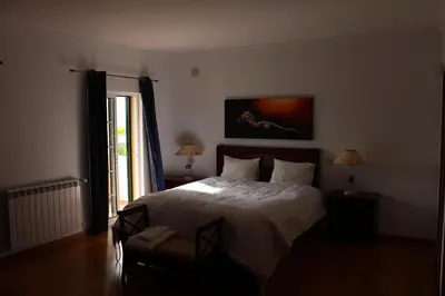 a bedroom with a large bed and a window at Vila Montechoro in Albufeira
