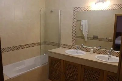 a bathroom with two sinks and a shower and a tub at Vila Montechoro in Albufeira