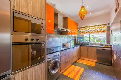 a kitchen with a washer and dryer in it at VILA RUINAS GAMITO in Guia