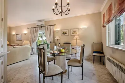 a kitchen and living room with a table and chairs at Mng Elliott52 in Vale do Lobo