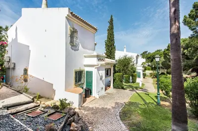 a white church with a palm tree in front of it at Mng Elliott52 in Vale do Lobo