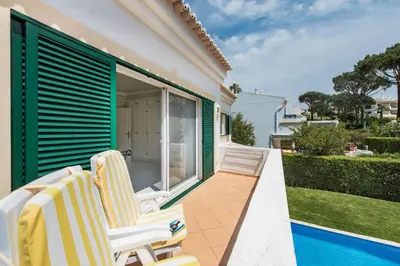 a patio with two chairs and a swimming pool at Mng Elliott50 in Vale do Lobo