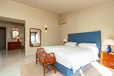 a bedroom with a large bed and a table and a mirror at Mng Elliott25 in Vale do Lobo