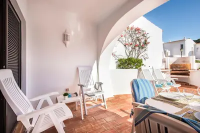 a patio with chairs and a table and an umbrella at Mng Elliott24 in Vale do Lobo