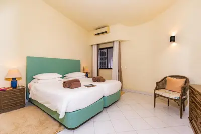 a bedroom with two beds and a chair in it at Mng Elliott24 in Vale do Lobo