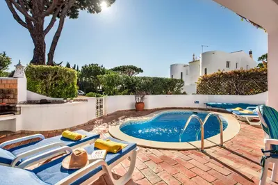 a swimming pool with lounge chairs and a swimming pool at Mng Elliott74 in Vale do Lobo