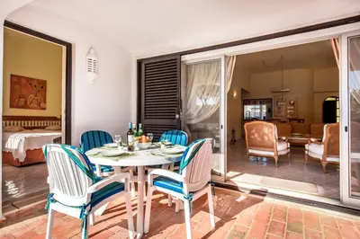 a dining room with a table and chairs and a bedroom at Mng Elliott74 in Vale do Lobo
