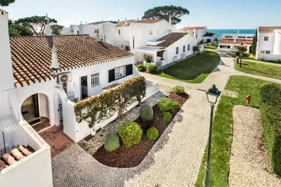 a white house with bushes and a street light at Mng Elliott74 in Vale do Lobo