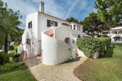 a white house with a spiral staircase in a yard at Mng Elliott91c in Vale do Lobo