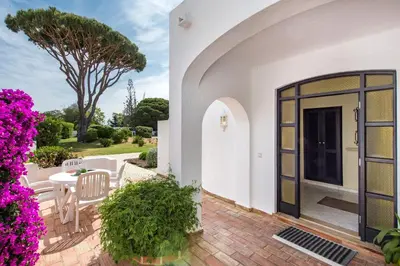 a villa with a door to a patio with purple flowers at Mng Elliott71 in Vale do Lobo