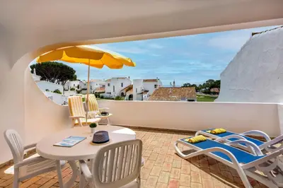a balcony with a table and chairs and an umbrella at Mng Elliott53 in Vale do Lobo