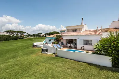 a dining room and living room with a table and chairs at Mng Elliott51 in Vale do Lobo