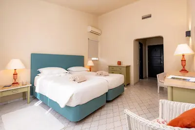 a bedroom with two beds and a table and chairs at Mng Elliott37 in Vale do Lobo