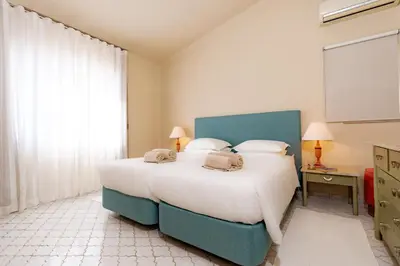 a bedroom with a bed and a chair and a mirror at Mng Elliott37 in Vale do Lobo