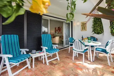 a patio with blue and white chairs and a table at Mng Elliott31 in Almancil