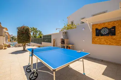 a ping pong table in the courtyard of a house at Vicente Mar Luxury Villa - Private Pool in Albufeira