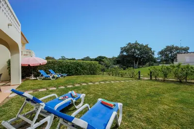 a group of blue and white lounge chairs in a yard at Tranquil Hideaway Olhos de Agua in Faro