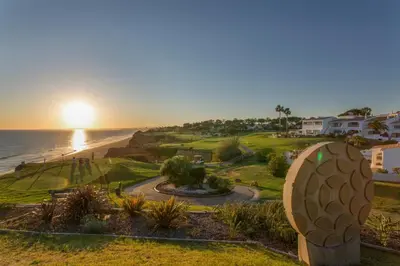 a view of the ocean from a resort with a sunset at Tranquil Hideaway Olhos de Agua in Faro