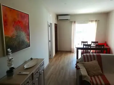 a living room with a sink and a table at Apartamento laranja Quarteira in Quarteira