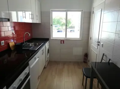a small kitchen with a sink and a window at Apartamento laranja Quarteira in Quarteira