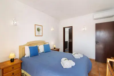 a bedroom with a blue bed with towels on it at Villa Aveiros in Albufeira