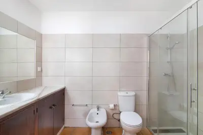 a bathroom with a toilet and a sink and a shower at Villa Aveiros in Albufeira