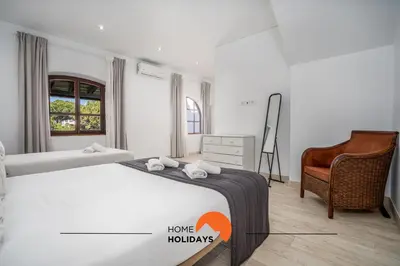 a bedroom with a bed and a chair and a bed and a desk at #213 Vila Roja Pé by Home Holidays in Albufeira