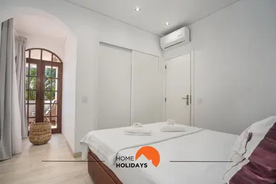 a bedroom with a bed with a home holidays sign on it at #213 Vila Roja Pé by Home Holidays in Albufeira