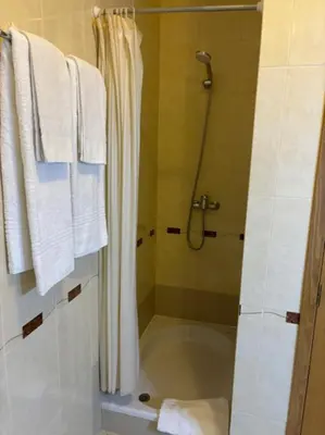 a shower in a bathroom with white towels at Apartment Blue Sun in Albufeira