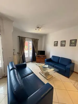 a living room with a blue couch and a table at Apartment Blue Sun in Albufeira