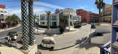 a view of a street with a white car and buildings at Apartment Blue Sun in Albufeira