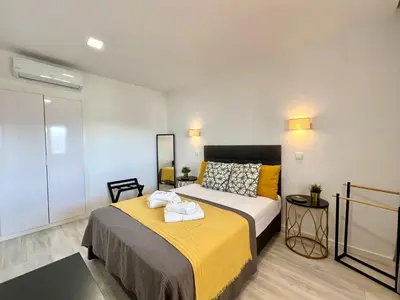 a bedroom with a bed with a yellow blanket at Albufeira Twins 3 With Pool by Homing in Albufeira