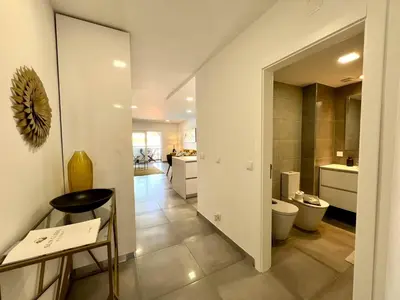 a white bathroom with a toilet and a kitchen at Albufeira Twins 3 With Pool by Homing in Albufeira