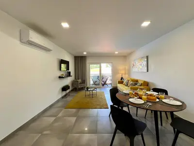 a living room with a table and a couch at Albufeira Twins 3 With Pool by Homing in Albufeira
