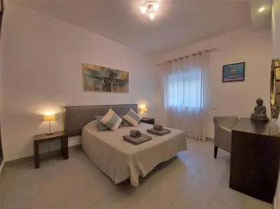 a bedroom with a bed and a couch and a table at Al Baltum in Albufeira