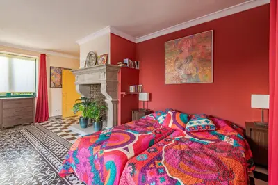 a red bedroom with a bed and a fireplace at TheBougainVilla our Oceanview Villa in the Hills in Boliqueime