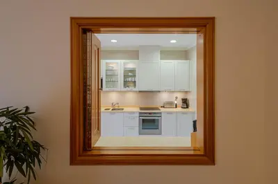 a mirror reflecting a kitchen with white cabinets at The Residences Vilamoura in Vilamoura