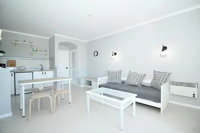 a white living room with a couch and a table at BelaVista Tenis SweetHouse in Albufeira
