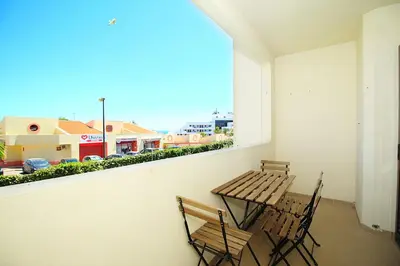 a balcony with two chairs and a table and a window at BelaVista Tenis SweetHouse in Albufeira