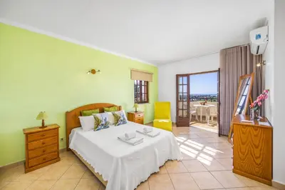 a bedroom with a large bed and a balcony at Villa Casa Coelho by Villa Plus in Terras Novas