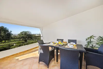 a dining room with a table and chairs on a balcony at Villa Casa Coelho by Villa Plus in Terras Novas