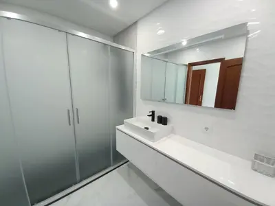 a white bathroom with a sink and a mirror at Beachfront flat with pool in Quarteira