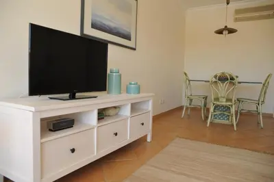 a living room with a flat screen tv on a white cabinet at Beach&Golf Vilamoura Apartment in Vilamoura